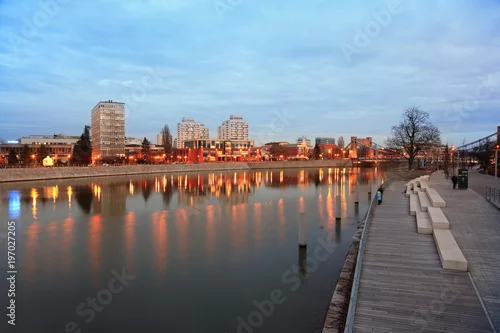 Naklejka na ścianę Budynki mieszkalne i most Grunwaldzki nad rzeką Odrą we Wrocławiu wieczorem.