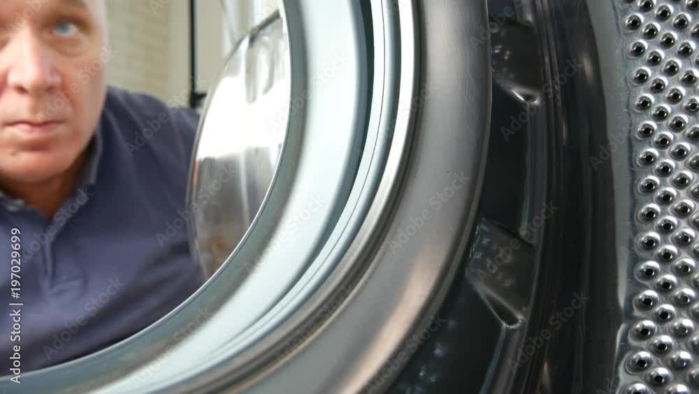 Man Open Front Door and Fill Washing Machine with Dirty Clothes Man Open Front Door and Fill Washing Machine with Dirty Clothes