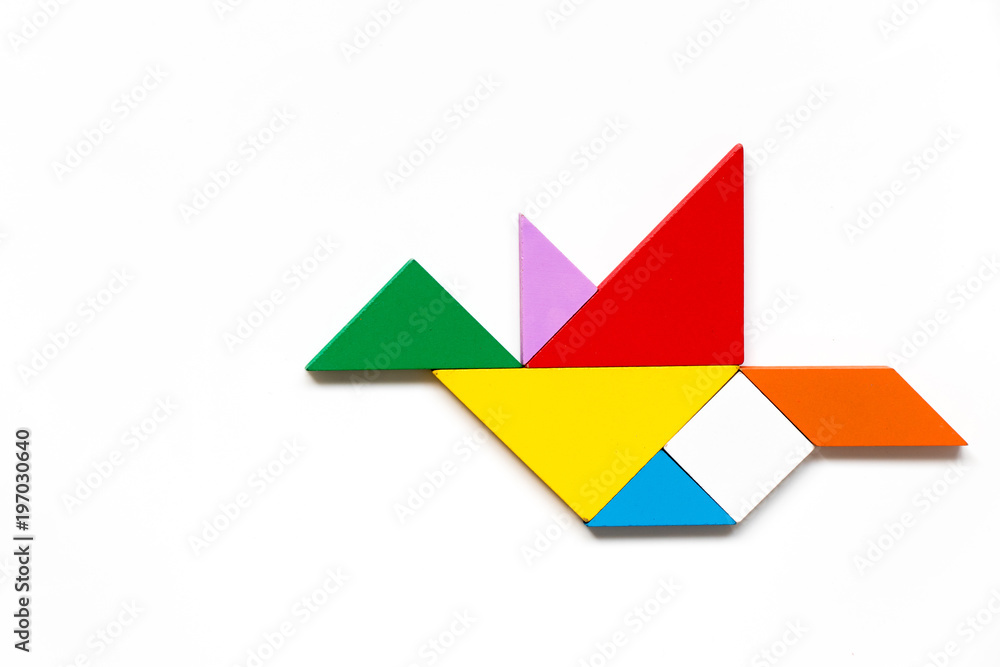 Color wood tangram puzzle in flying bird shape on white background Color wood tangram puzzle in flying bird shape on white background