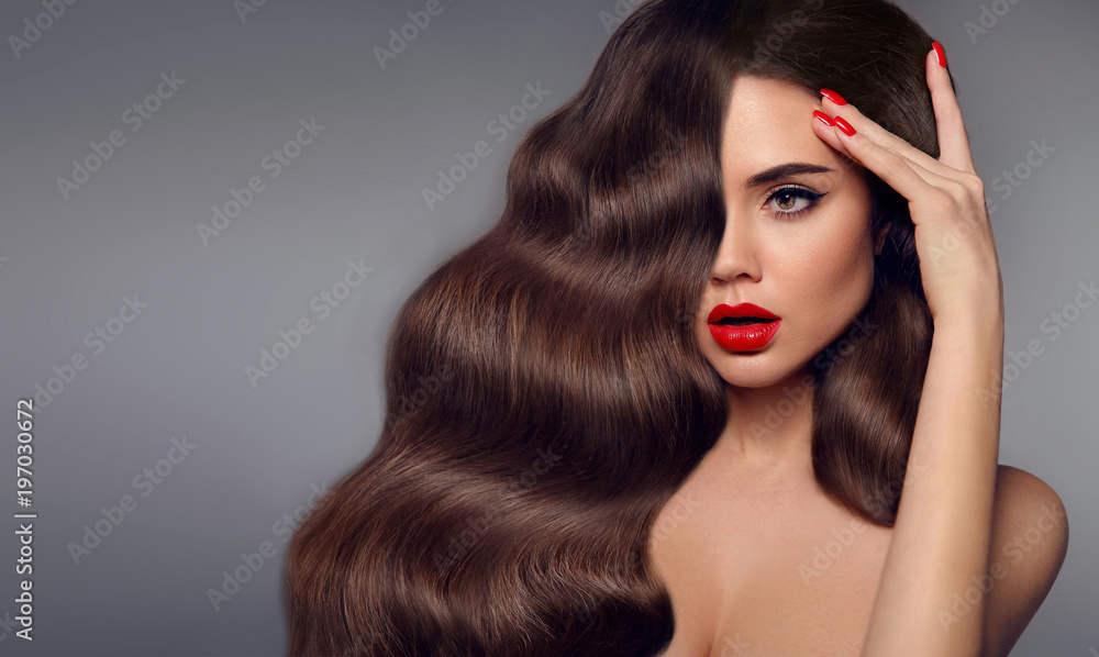 Beauty hair girl portrait. Red lips makeup, manicure nails and healthy wavy hairstyle. Sexy beautiful woman surprise looking to the side holds fingers near the head. Expressive facial expressions. - obrazy, fototapety, plakaty 