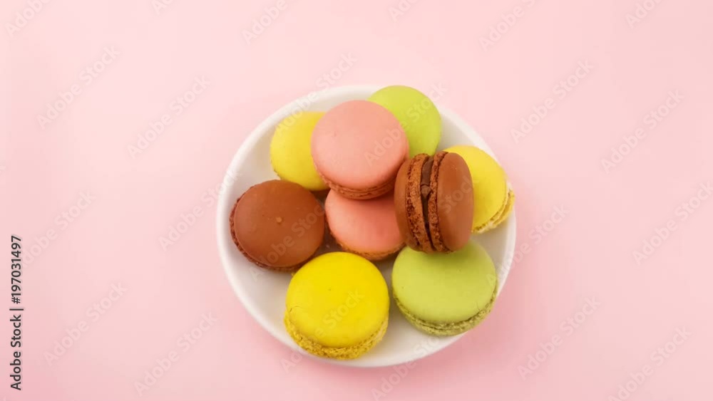 Macaroons or macaron in white plate on pastel pink surface. Close up macro. Macaroons or macaron in white plate on pastel pink surface. Close up macro.