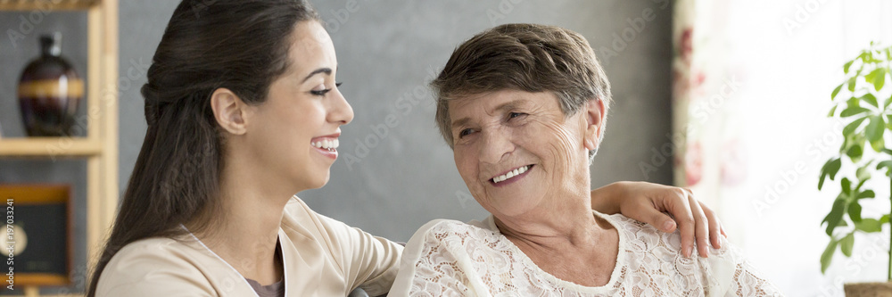 Granddaughter hugging smiling senior woman Granddaughter hugging smiling senior woman