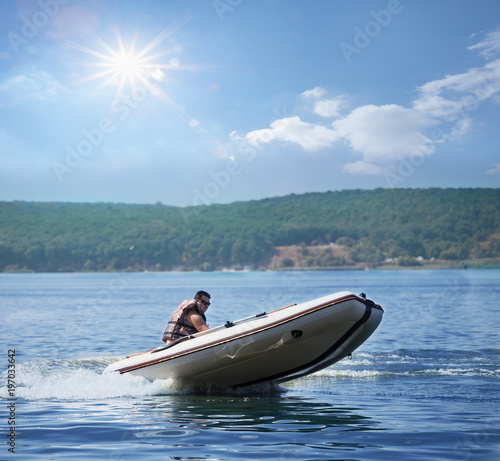 Man on white inflatable motor boat