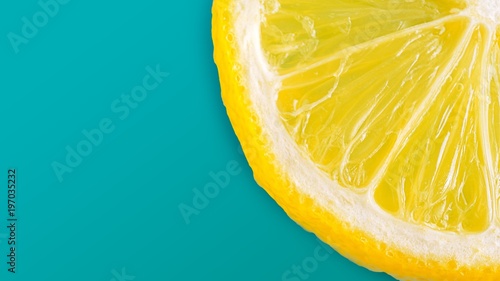 The half slice of the fresh lemon on cyan pastal color background photo