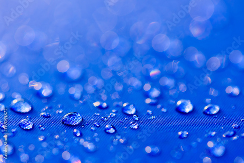 Close up Water drops pattern over a blue waterproof cloth background. World Water Day concept.
