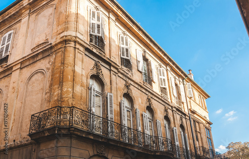 Old house in decay with forged balcony railings in Aix-en-Provence, France