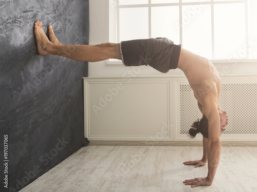 Young man practicing yoga with gymnastic mat photo