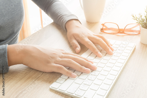 Asian female hands are using a computer keyboard.