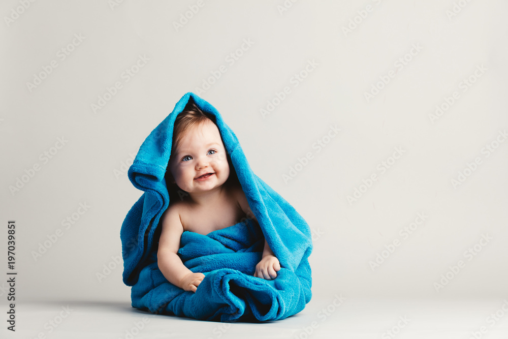Baby girl covered with a blue warm blanket - obrazy, fototapety, plakaty 