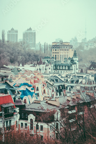 City of Kyiv (Kiev), capital of Ukraine, panorama. Colorful houses of Vozdvizhenka (Vozdvizhenska) elite district. Kitsch. Cloudy spring afternoon. Wet rooftops. Vintage colors photo