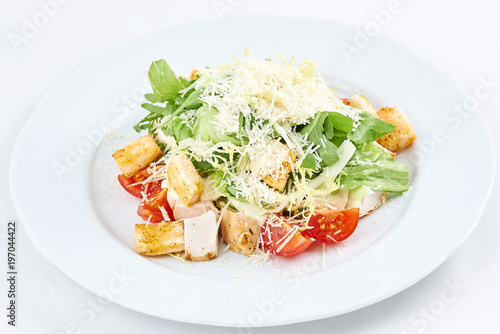 Delicious caesar salad. Caesar salad with cheese, chicken, tomatoes, rusks and green leaves of arugula.