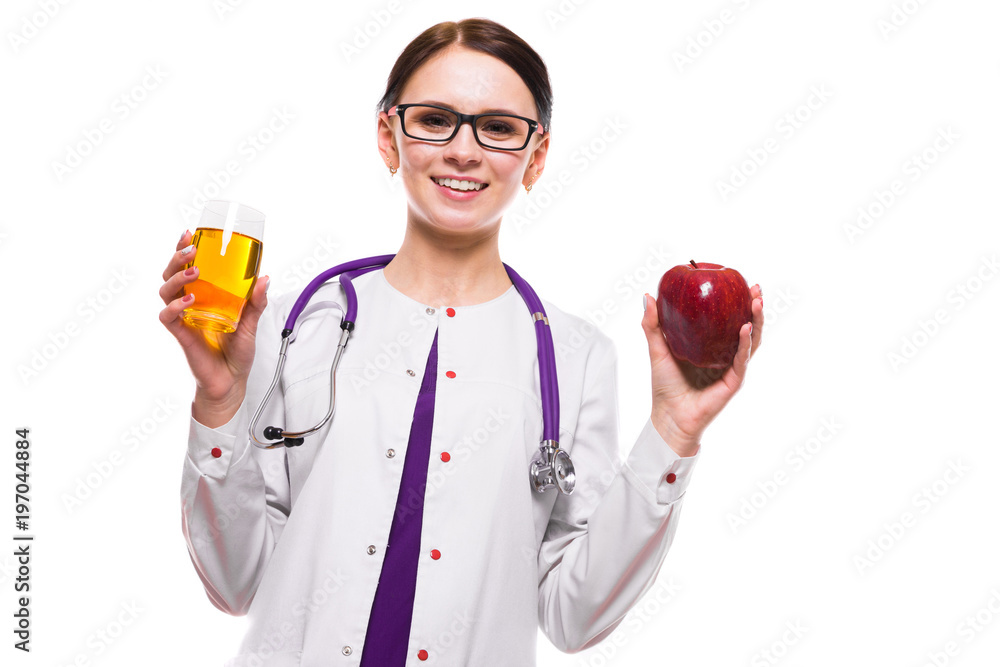 Female nutritionist holding apple and glass of fresh juice in her hands on white background Female nutritionist holding apple and glass of fresh juice in her hands on white background
