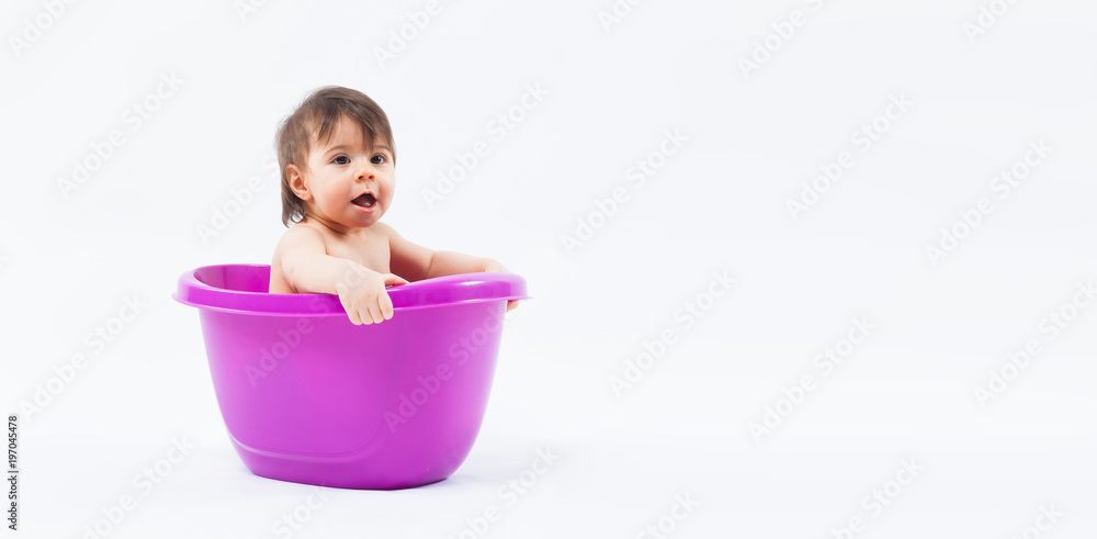 Adorable caucasian girl taking bath in purple tub on white background Adorable caucasian girl taking bath in purple tub on white background