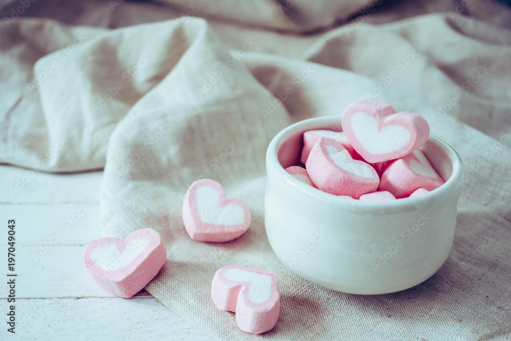 Heart shape marshmallows in white mug on wood background, sweet and love concept Heart shape marshmallows in white mug on wood background, sweet and love concept