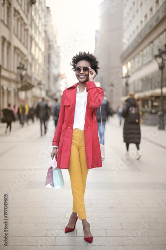 Girl doing shopping in the city, walking holding shopping bags © merla