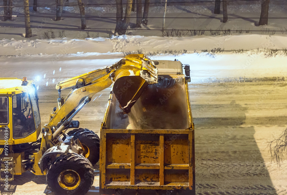 loader removes snow in the night