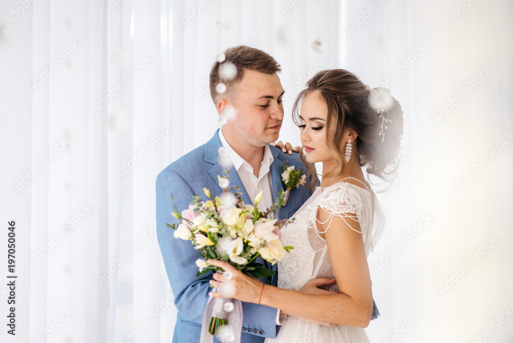 The groom hugs the bride in the room. The groom hugs the bride in the room.