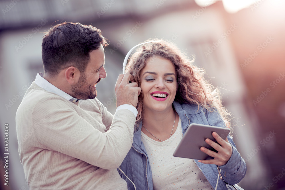 Fototapeta premium Trendy young couple listening music on a digital tablet