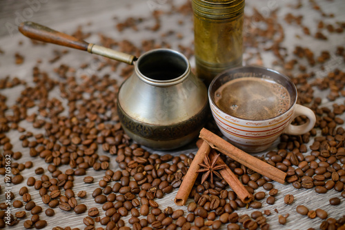 Antique coffee grinder with cup, coffee maker and beans