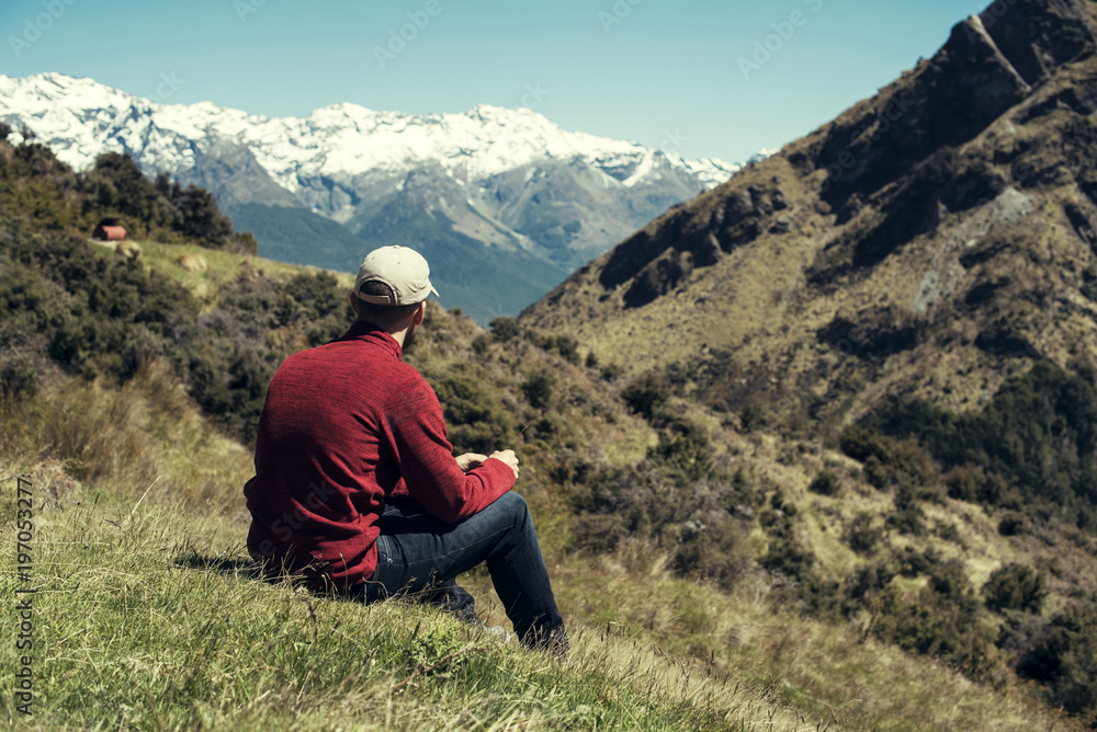 Hombre joven disfrutando de las vistas de un paisaje con montañas evadas en Nueva Zelanda Hombre joven disfrutando de las vistas de un paisaje con montañas evadas en Nueva Zelanda
