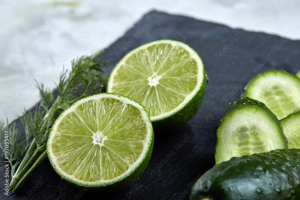 Concept of fresh green lettuce, cucumber, dill, lime on a light background, selective focus, top view, copy space. Concept of fresh green lettuce, cucumber, dill, lime on a light background, selective focus, top view, copy space.