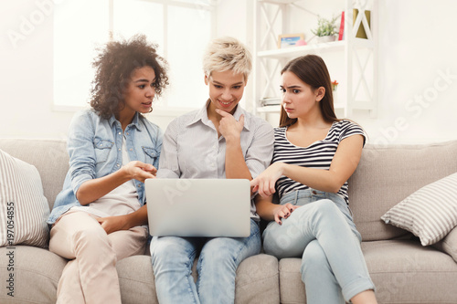 Three beautiful women using laptop at home