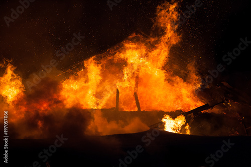 Burning fire flame on wooden house roof