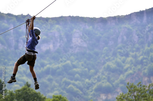 young woman hanging on a climbing rope