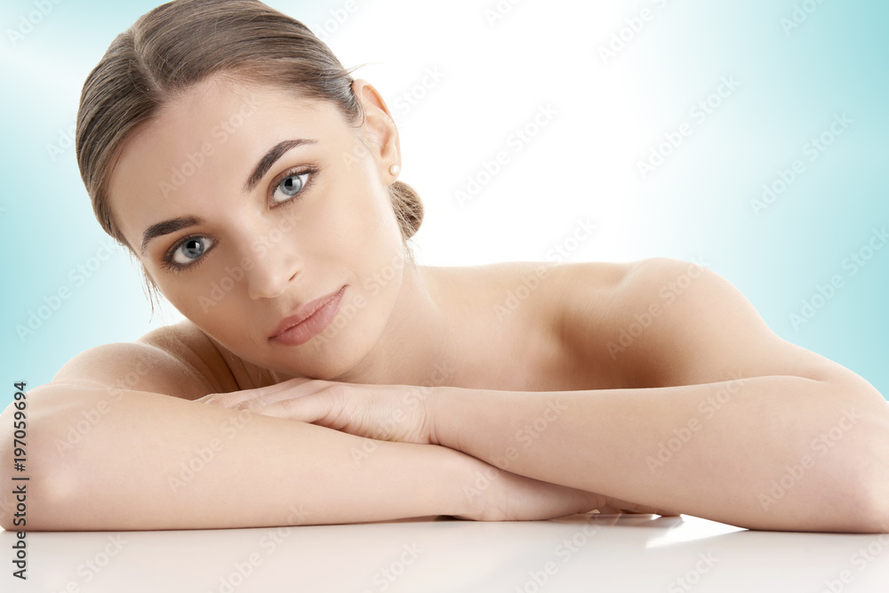 Flawless beauty. Close-up portrait of an attractive woman with perfect skin looking at camera while posing against at isolated light blue background. Flawless beauty. Close-up portrait of an attractive woman with perfect skin looking at camera while posing against at isolated light blue background.