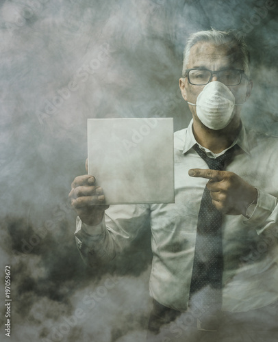 Businessman holding a sign and air pollution