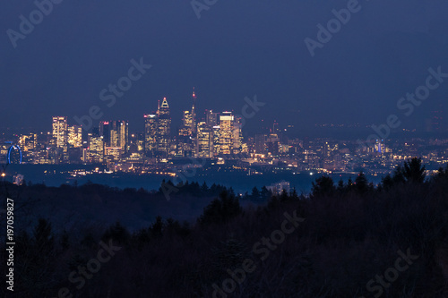 Skyline Frankfurt in der Dämmerung hinter den Wäldern des Taunus