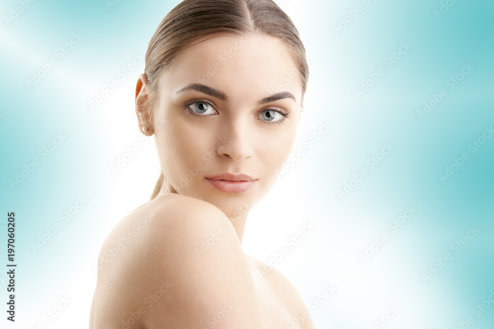 Flawless beauty. Close-up portrait of an attractive woman with perfect skin looking at camera while posing against at isolated light blue background. Flawless beauty. Close-up portrait of an attractive woman with perfect skin looking at camera while posing against at isolated light blue background.