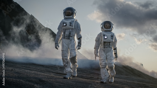 Two Astronauts in Space Suits Confidently Walking on Alien Planet, Exploration of the the Planet's Surface. In the Background Research Base/ Station and Rover. Space Travel, Colonization Concept.