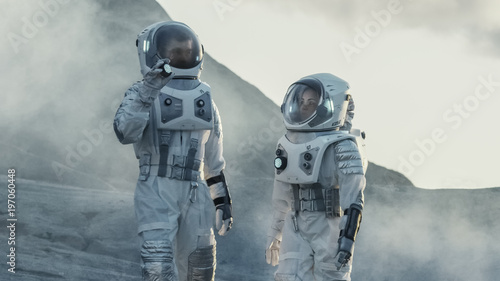 Two Astronauts Explore Rocky Alien Planet in the Day Time. Near Future and Technological Advance Brings Space Exploration, Travel, Colonization Concept.