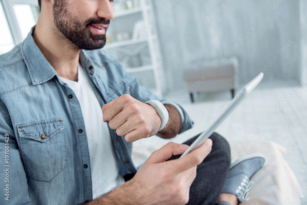 Need to work. Positive delighted brunette keeping smile on his face and making fist while looking at his gadget Need to work. Positive delighted brunette keeping smile on his face and making fist while looking at his gadget