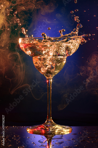 cocktail splashing in a dark blue smoky background