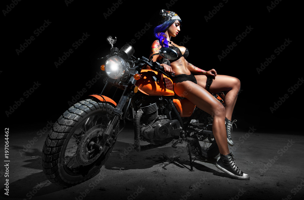 Fototapeta premium Stylowy chopper motocyklowy z seksownym tatuażem piskląt w nocy