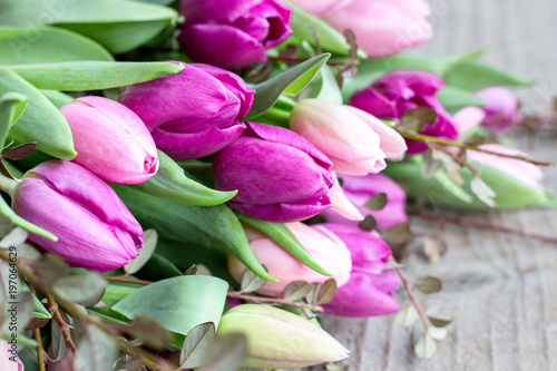 Fototapeta Naklejka Na Ścianę i Meble -  bouquet of pink and violett tulips  / beautiful bouquet of pink and violet tulips on a wooden background