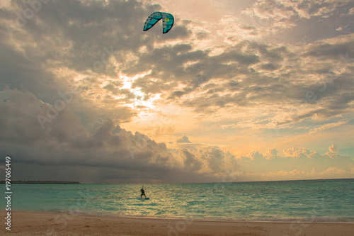 A kitesurfer surfs near the beach near a resort in Maldives