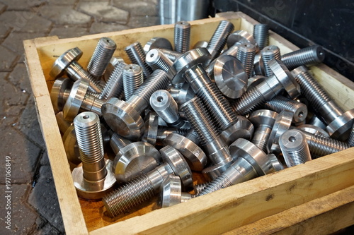 Bolts in a wooden box in the warehouse after turning and milling.