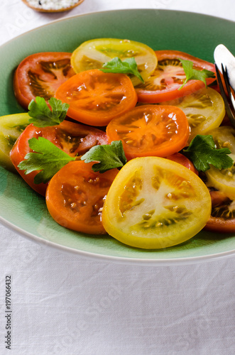 Colorful heirloom tomatoes salad on white