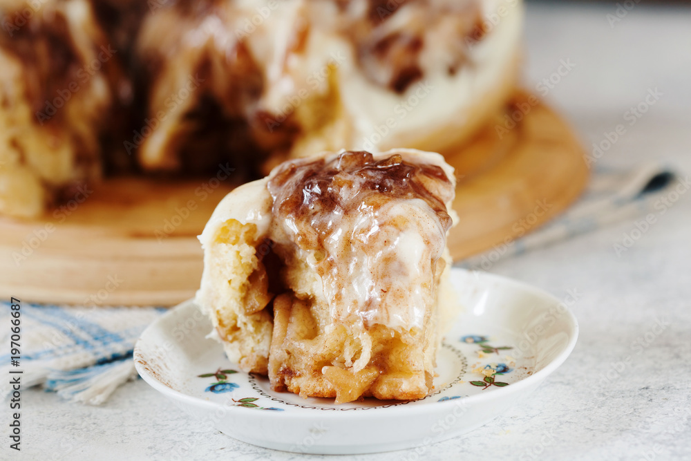 Homemade cinnamon roll with cream sauce on the plate Homemade cinnamon roll with cream sauce on the plate