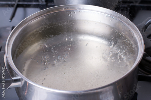 Boiling water in pan on stove in the kitchen