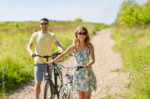 happy couple with bicycles on country road