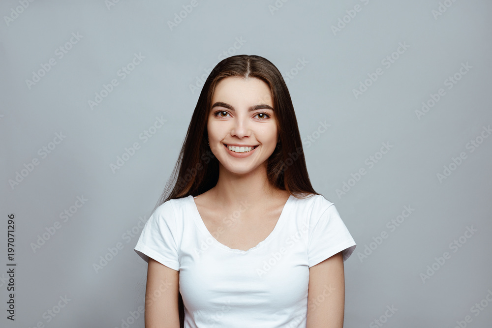 body languageand emotions. Portrait of the young beautiful woman brunette with long dark brilliant hair. The girl poses on a white background.smiling looking at camera. body languageand emotions. Portrait of the young beautiful woman brunette with long dark brilliant hair. The girl poses on a white background.smiling looking at camera.