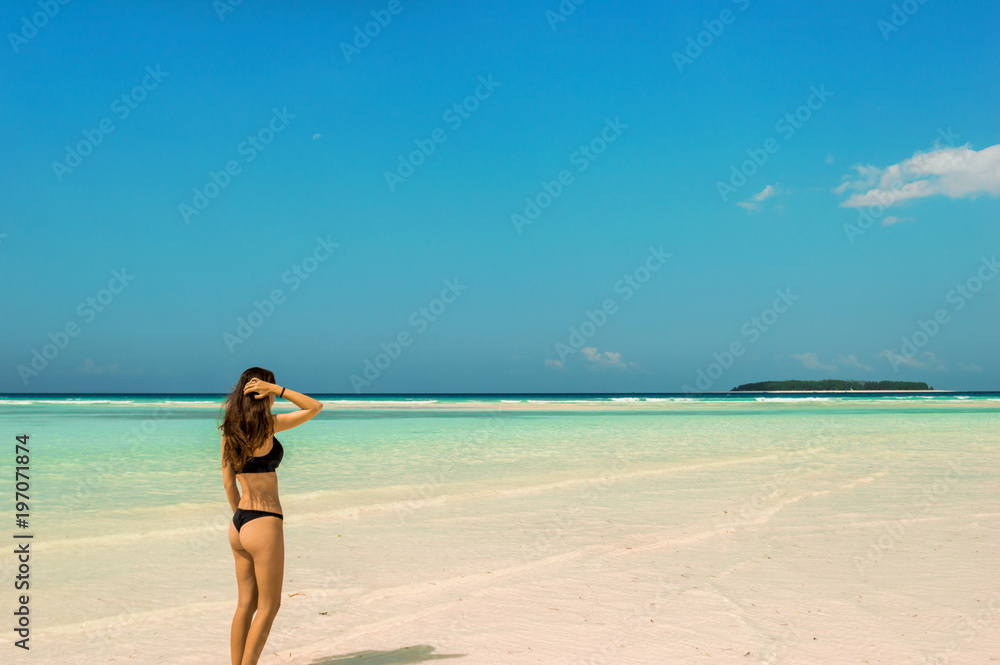 Woman spending summer holiday sunbathing on the Zanzibar beach during sunny day Woman spending summer holiday sunbathing on the Zanzibar beach during sunny day
