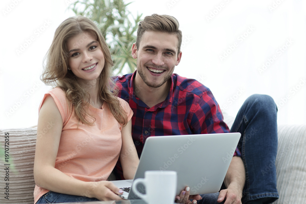 young couple .working on laptop sitting on sofa