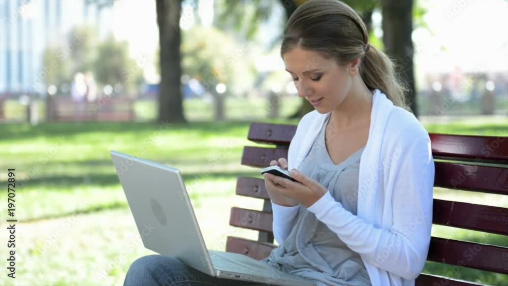 Young woman sitting in park with laptop Young woman sitting in park with laptop