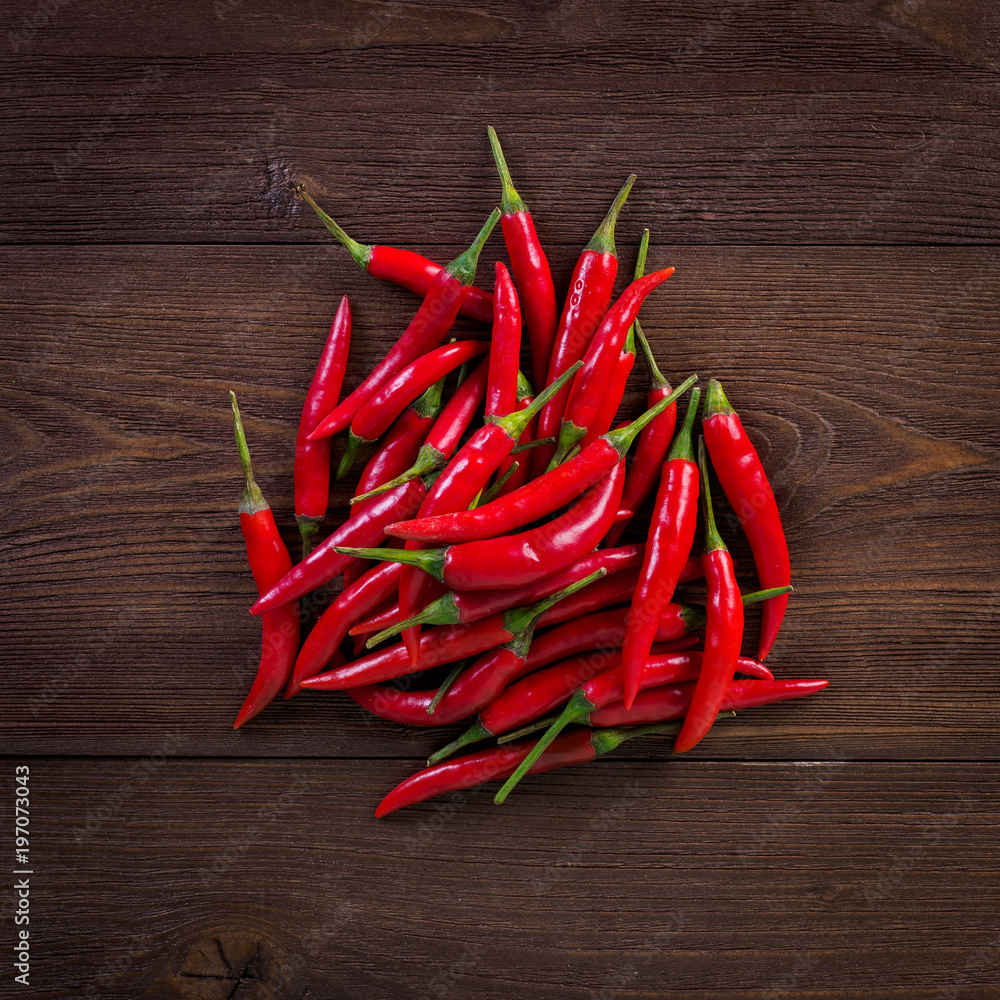 Red hot chili pepper on dark wooden background, top view.