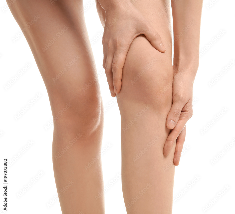 Young woman suffering from knee pain on white background
